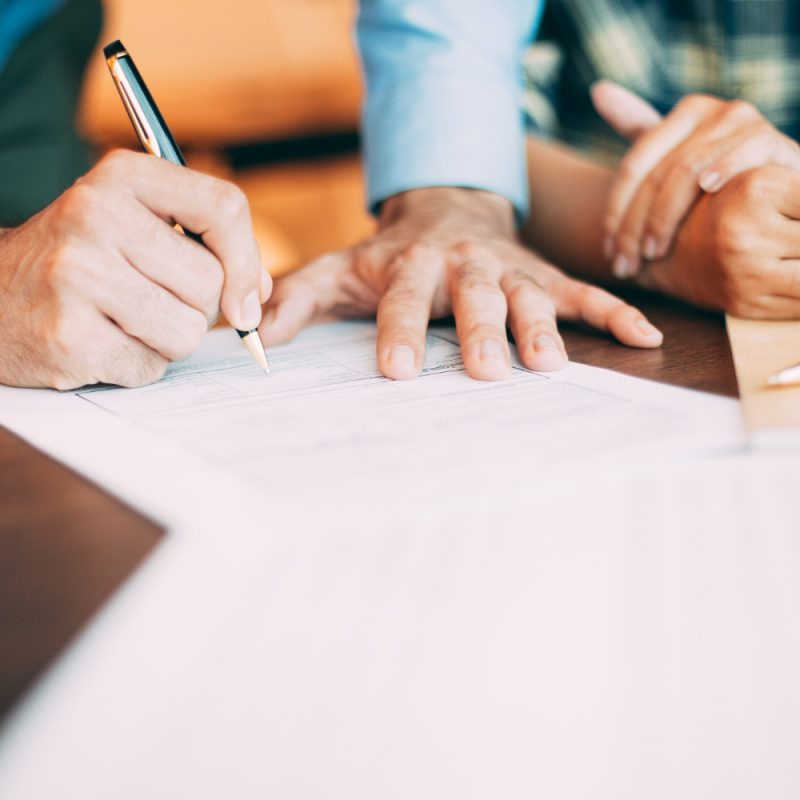 Un homme signe un document administratif avec un stylo